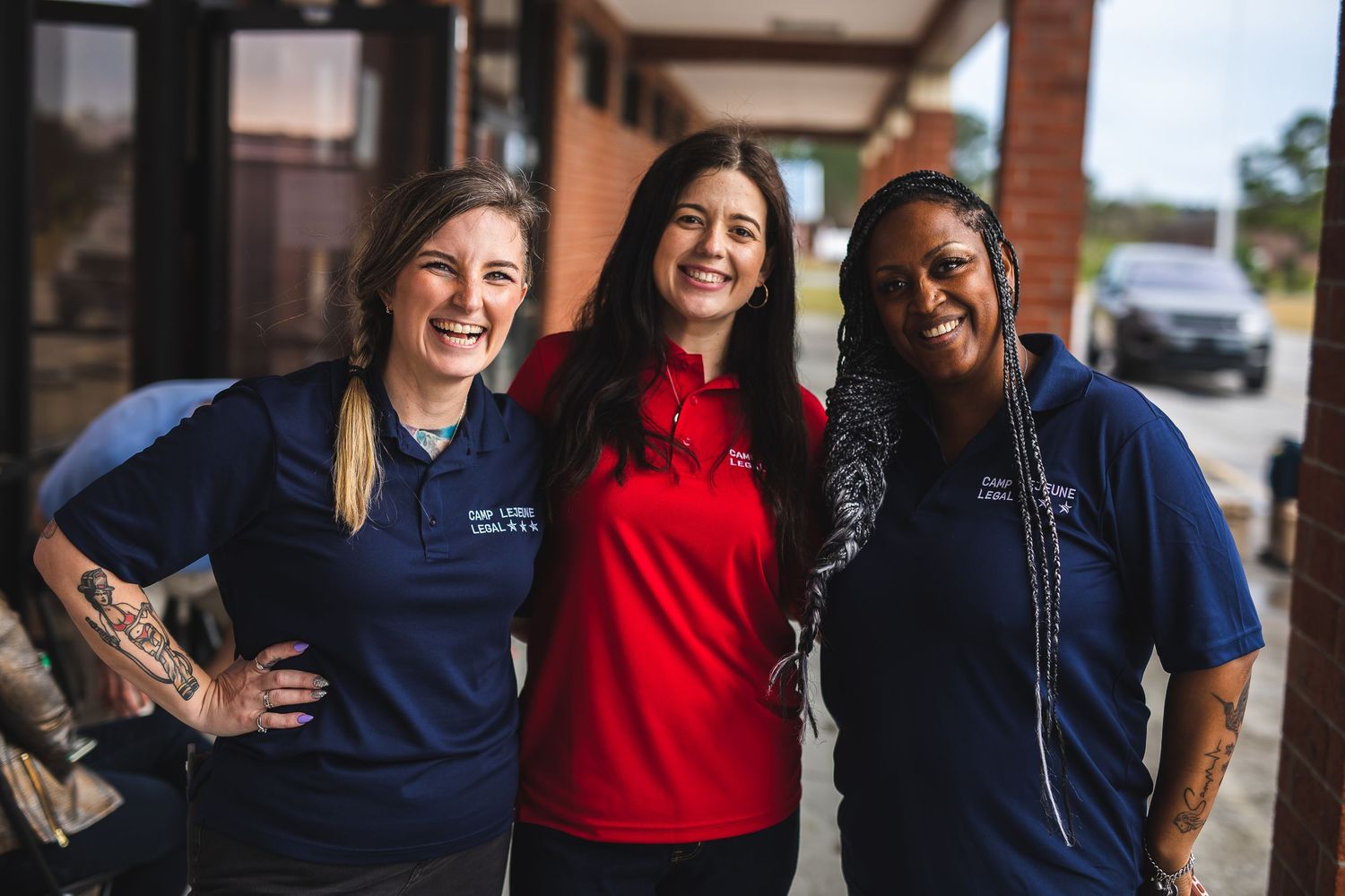 Three staff members in uniform standing together outside a restaurant.