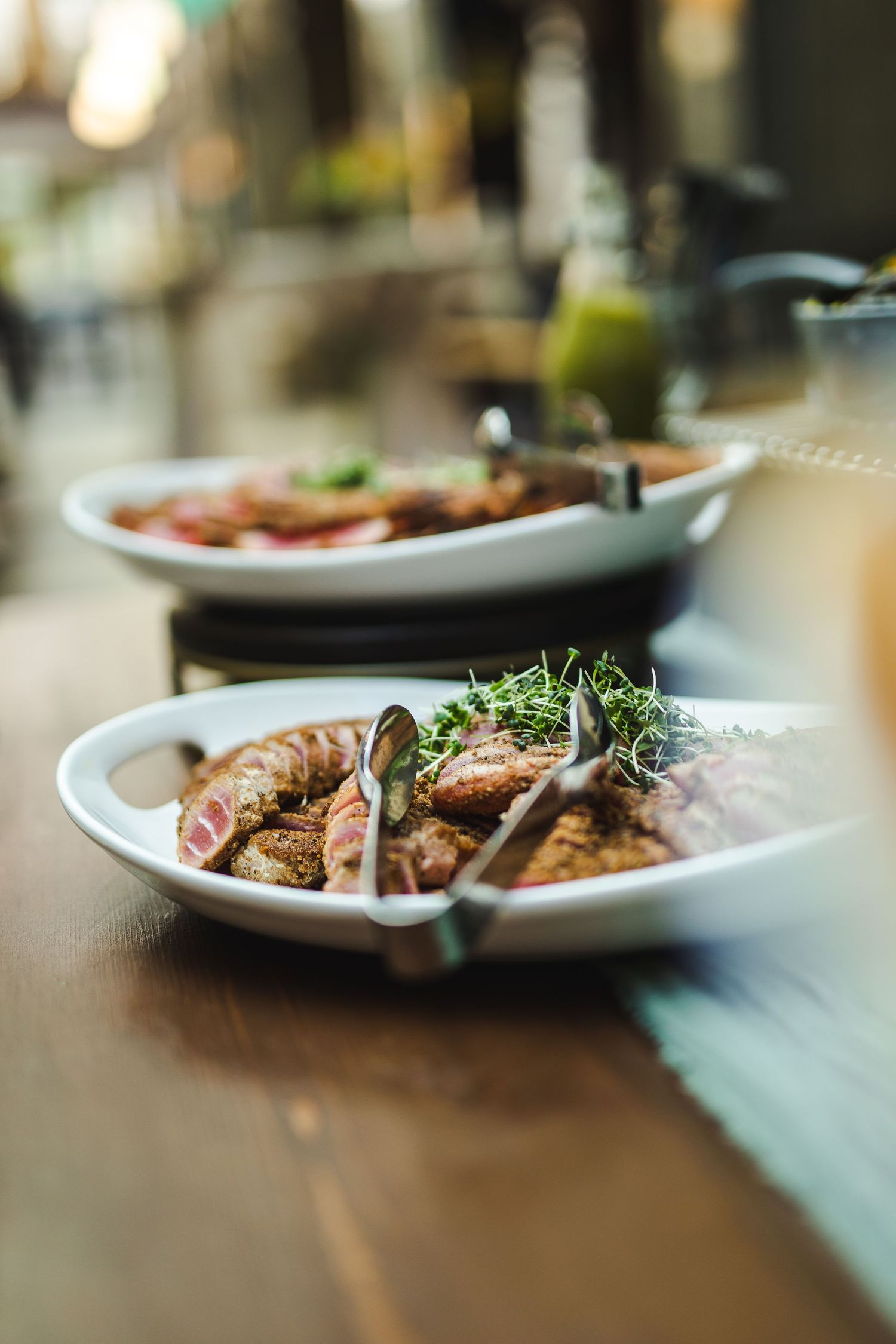 Close-up of a gourmet dish with garnished seafood on a white plate in a restaurant setting.