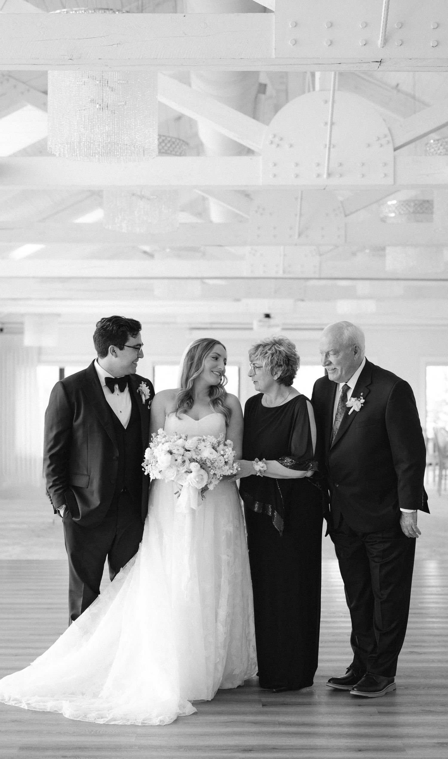 A romantic black and white wedding photo capturing an intimate moment under a delicate veil.
