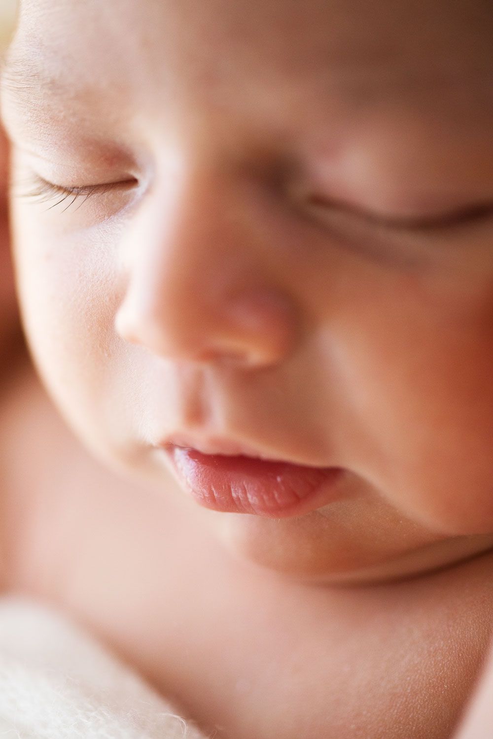 Close-up portrait of a peaceful sleeping baby with soft lighting creating a gentle, dreamy atmosphere.