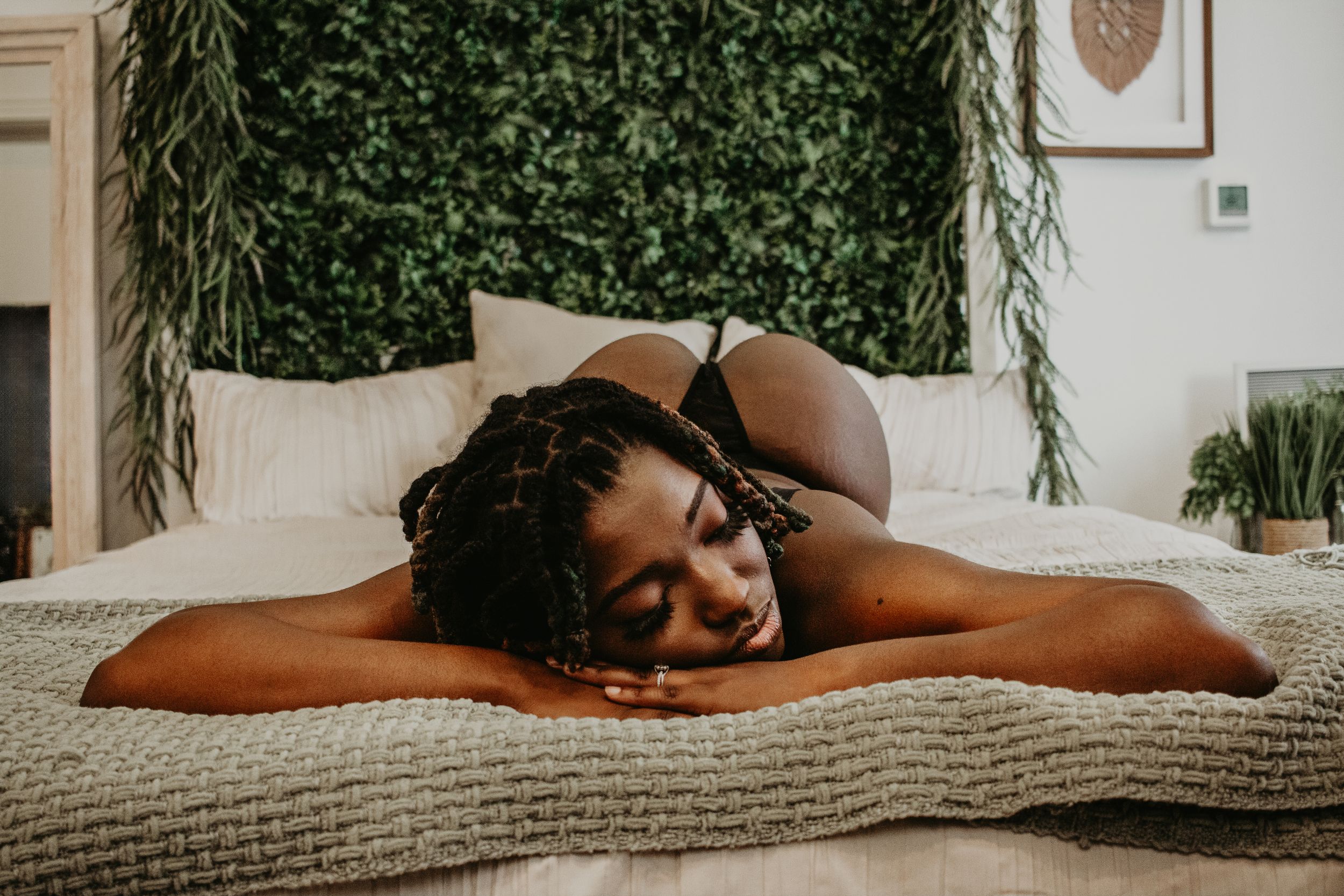 Intimate portrait on a neutral cushion with a leafy green wall backdrop.