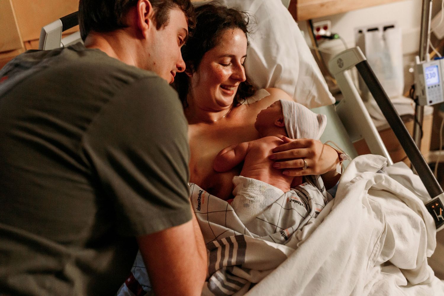 mom and dad bonding with newborn baby girl postpartum in Tulsa