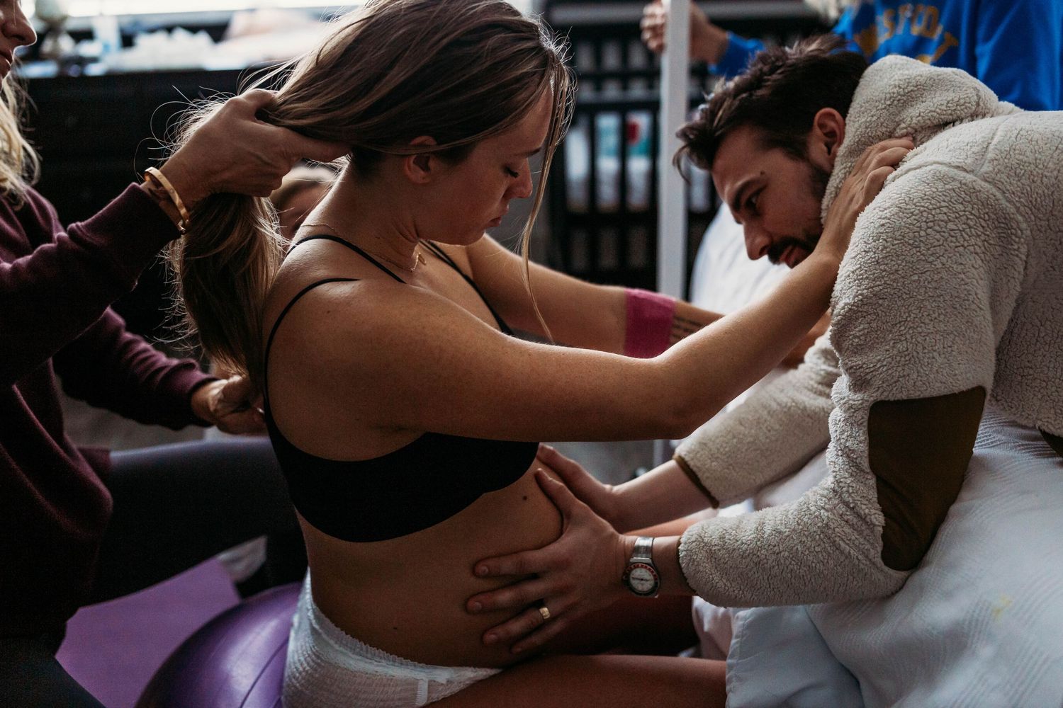 dad rubbing moms belly during labor at breathe birthing center in tulsa