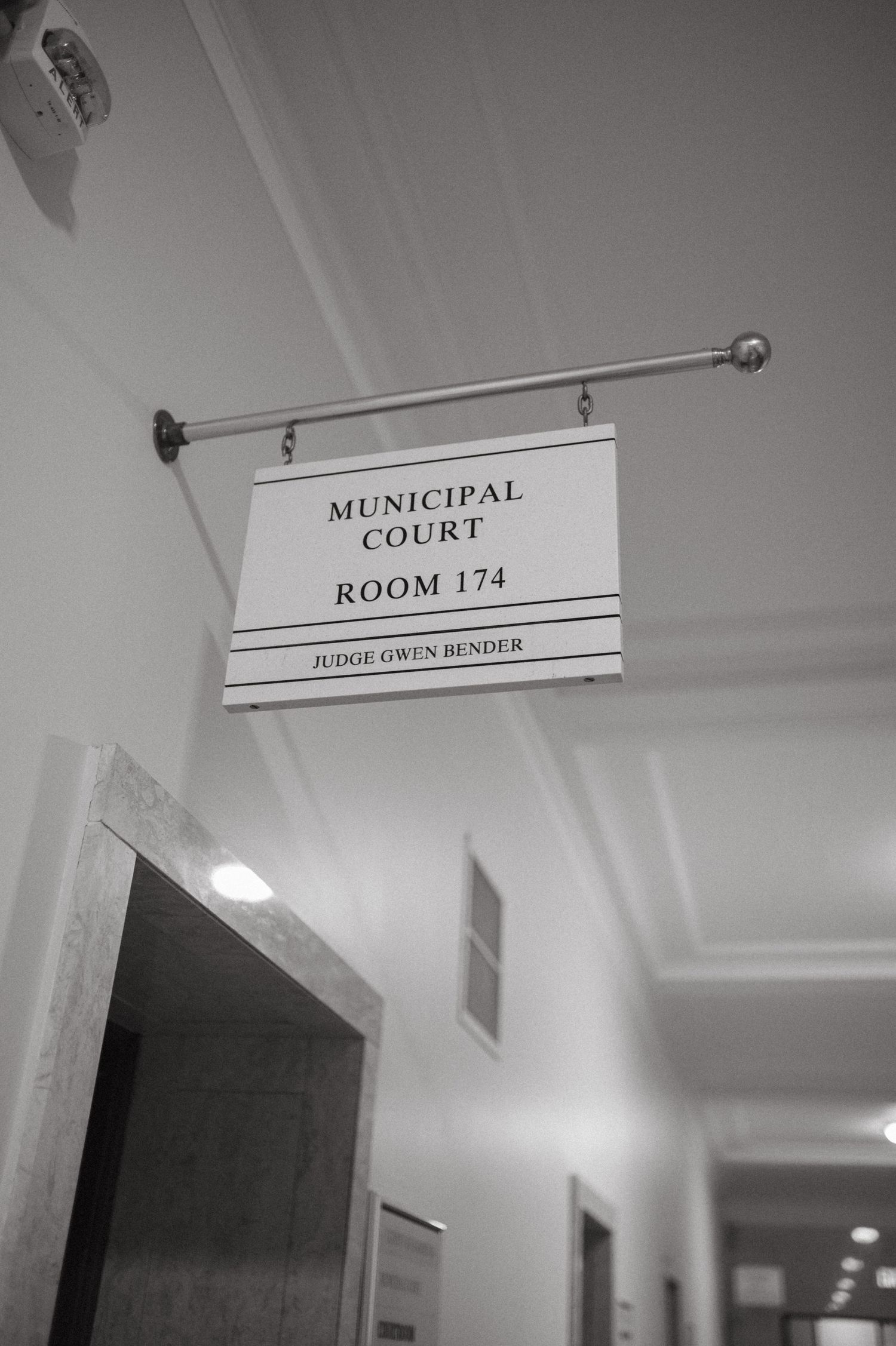 Municipal Court Room 174 sign mounted on wall in hallway.