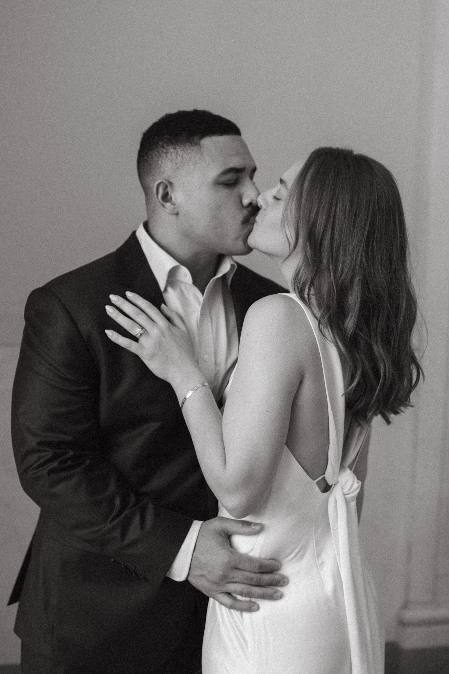 Intimate black and white portrait of couple sharing romantic kiss.