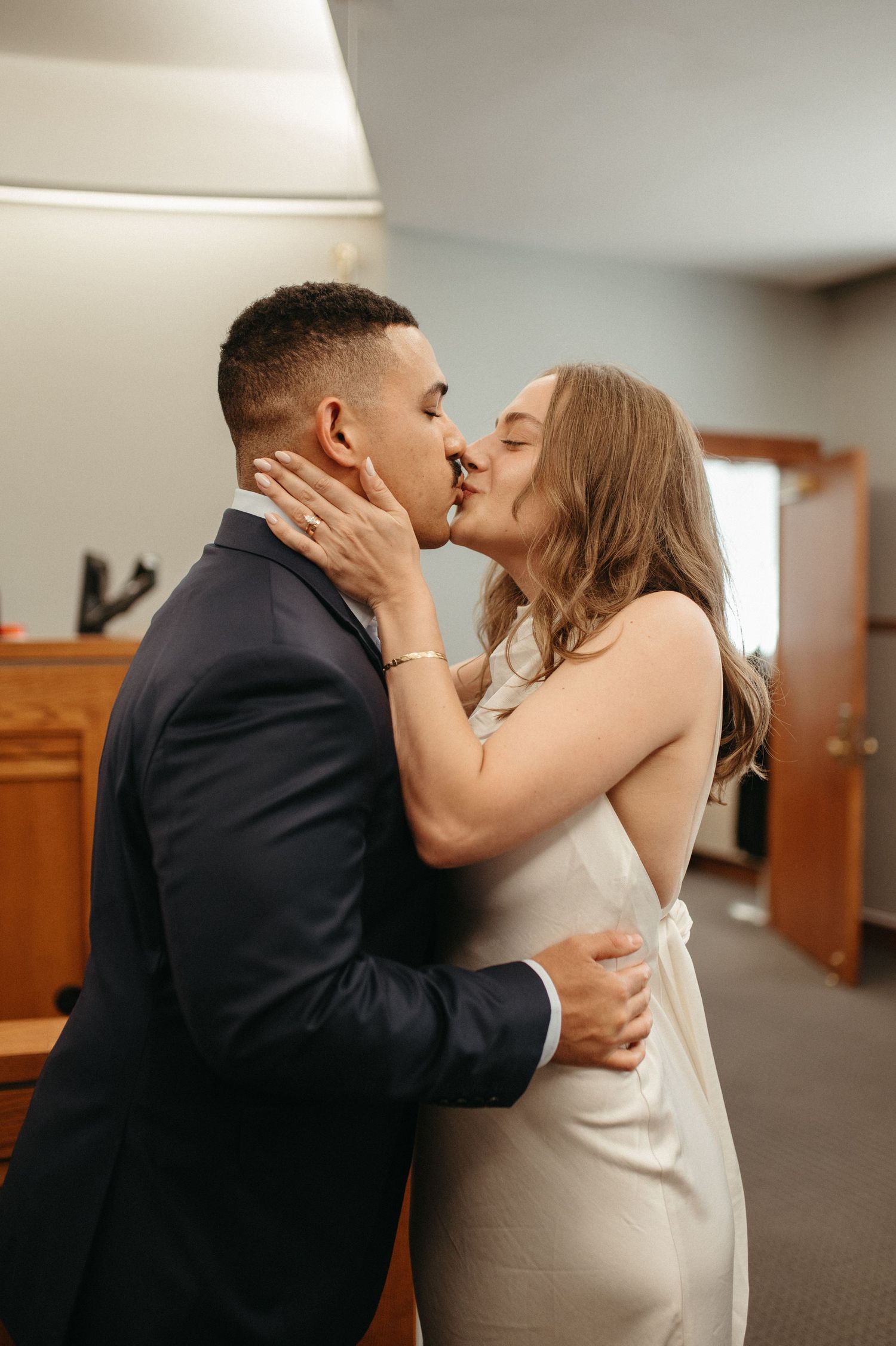 Newlyweds share their first kiss at courthouse wedding.