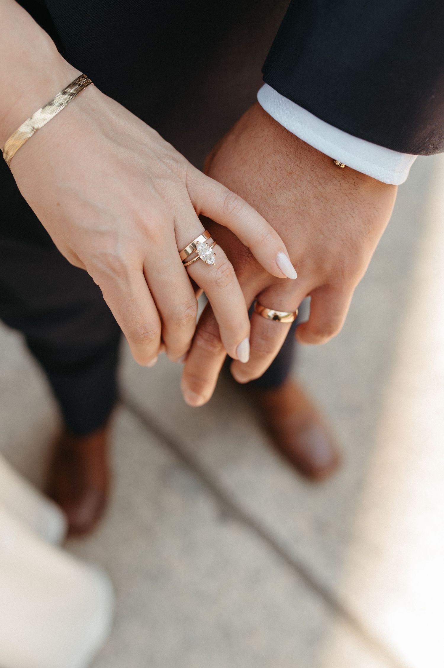 Close-up of hands wearing wedding rings and jewelry during a ceremony.