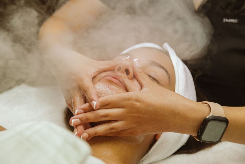 Close-up shot of facial massage during professional spa treatment with steam.