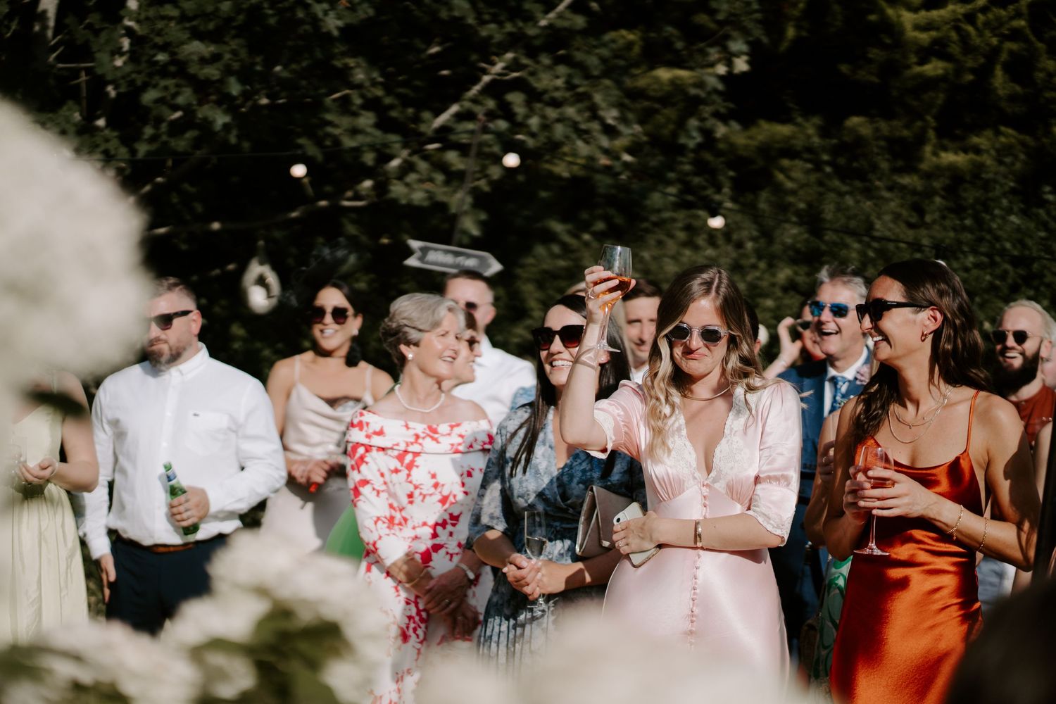 bridesmaid raising glass during speeches at marquee wedding in islip in Oxfordshire