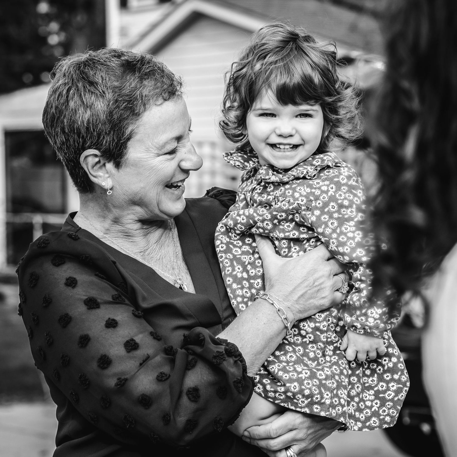 grandmother holding toddler and laughing