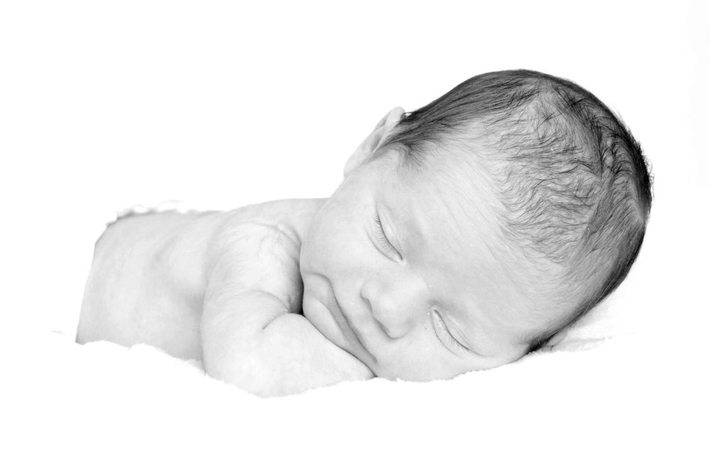 black and white newborn photo sleeping on white background