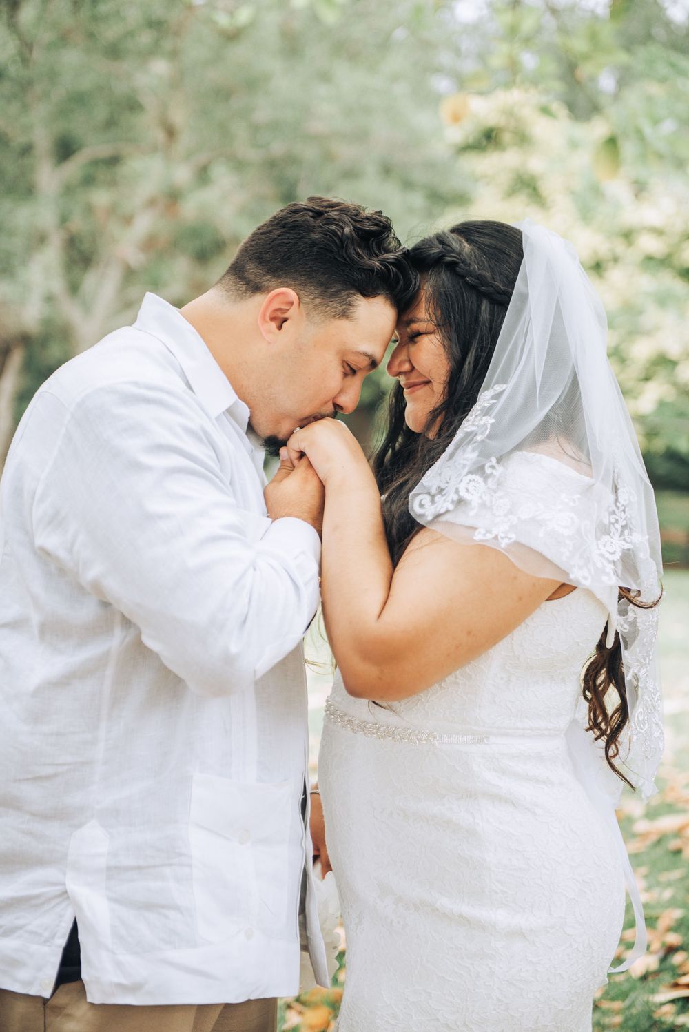 Wedding couple sharing intimate moment in outdoor setting.