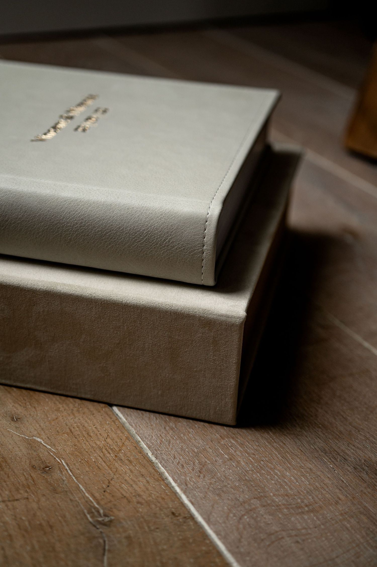 Close-up detail of grey leather book cover texture on wooden surface.