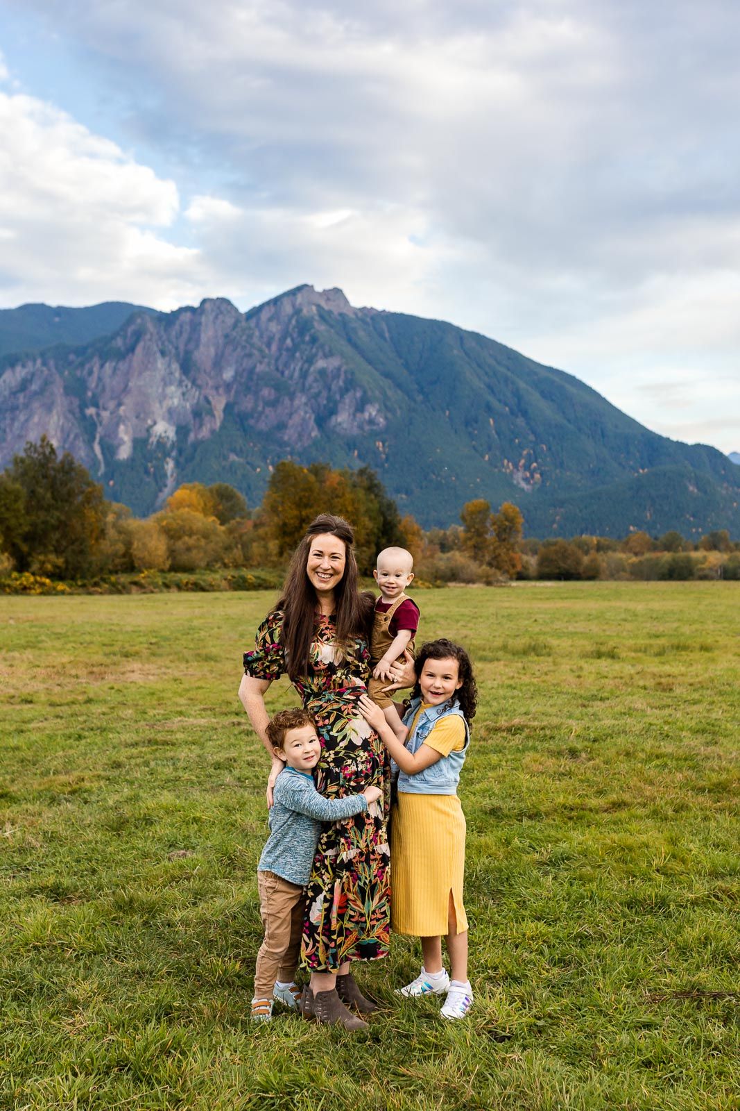 Mother hugging her three children at outdoor fall family photos.