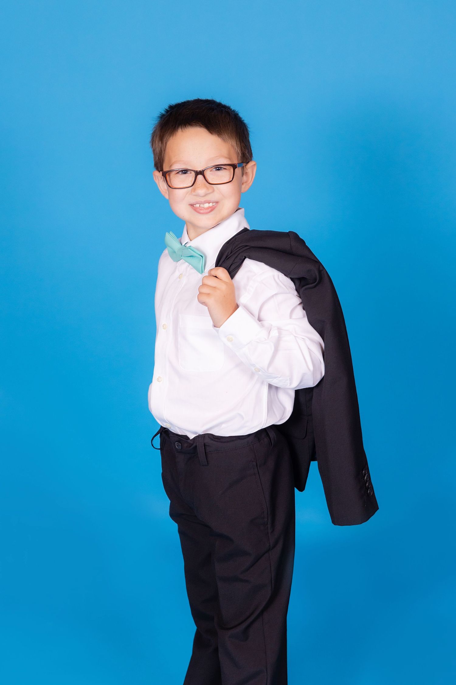 child in suit with jacket over shoulder on savage blue jay backdrop in studio in clayton new jersey gloucester county