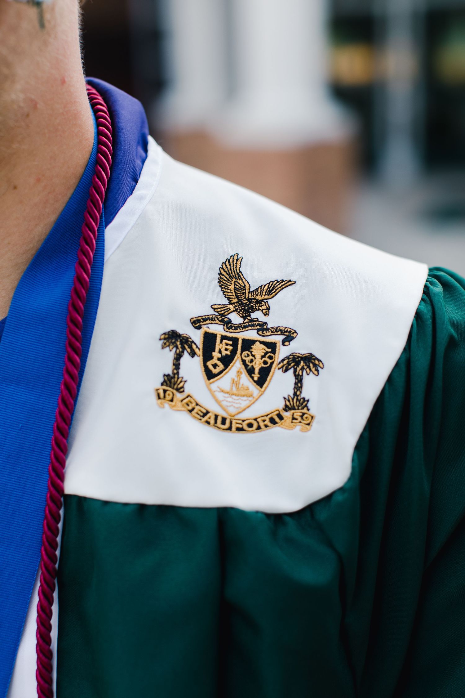 Close-up of Beaufort High School graduation gown emblem with eagle crest for senior photography session.