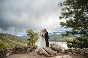 A romantic mountain wedding ceremony overlooking Sapphire Point in Colorado with dramatic storm clouds and mountain views.