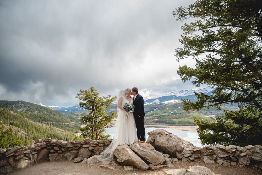 A romantic mountain wedding ceremony overlooking Sapphire Point in Colorado with dramatic storm clouds and mountain views.