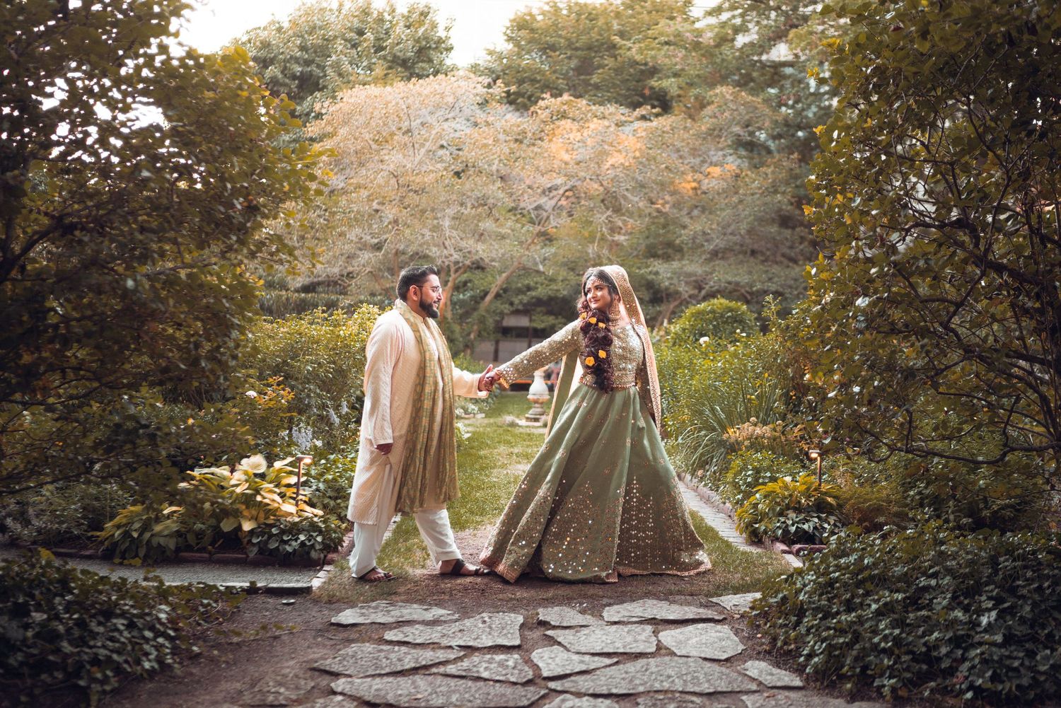 Bride and groom adorned in verdant attire, immersed in a fairytale-like green garden, where dreams come to life