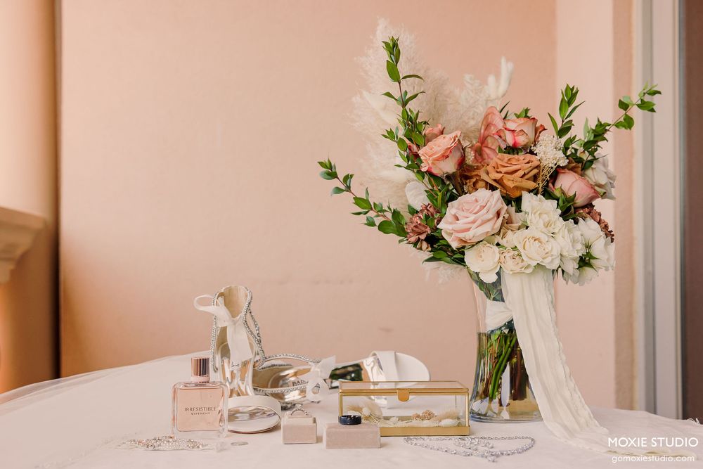 Wedding reception table setting with pink and white floral centerpieces and crystal glassware.