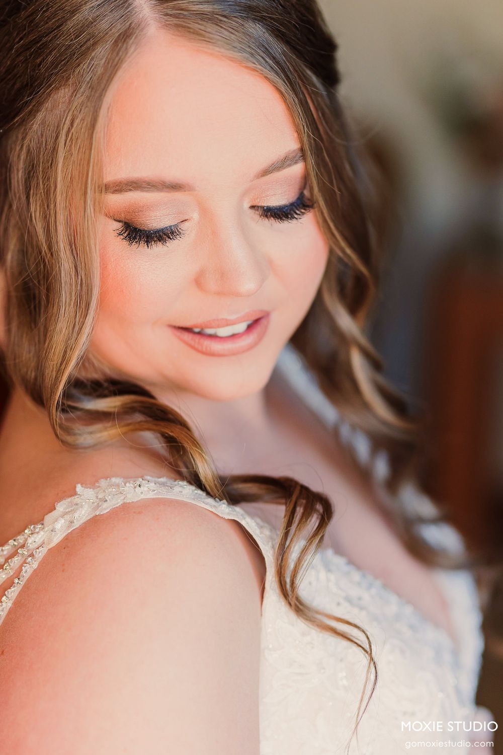 Close-up detail of delicate lace and beading on a white wedding gown.