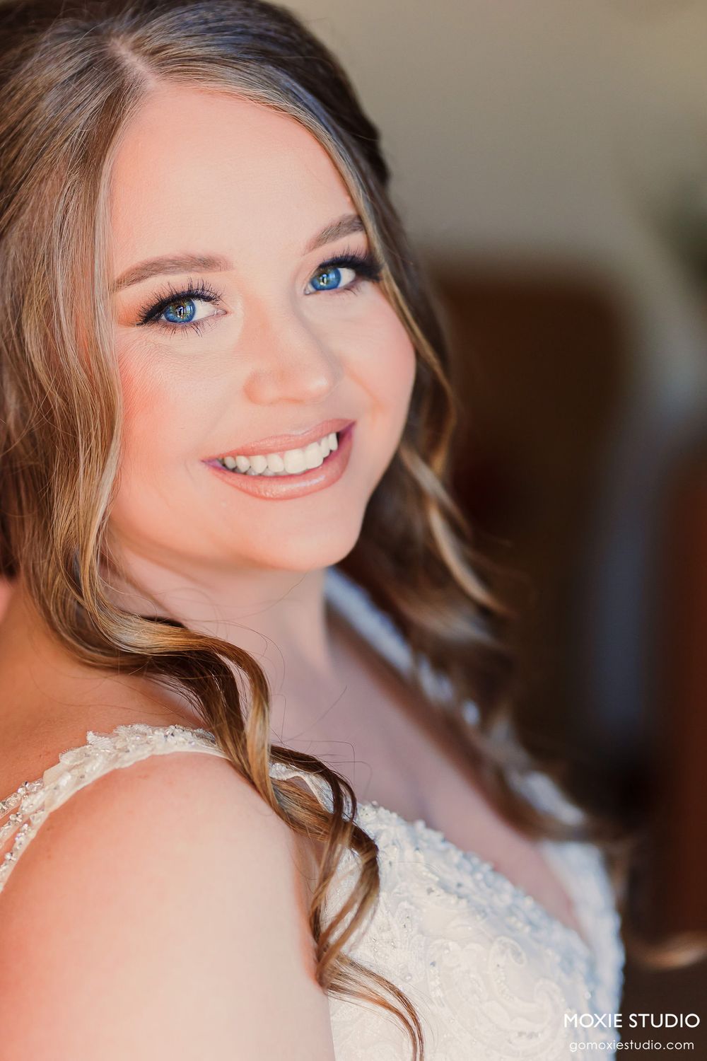 Soft romantic bridal portrait showcasing natural makeup and flowing hairstyle.