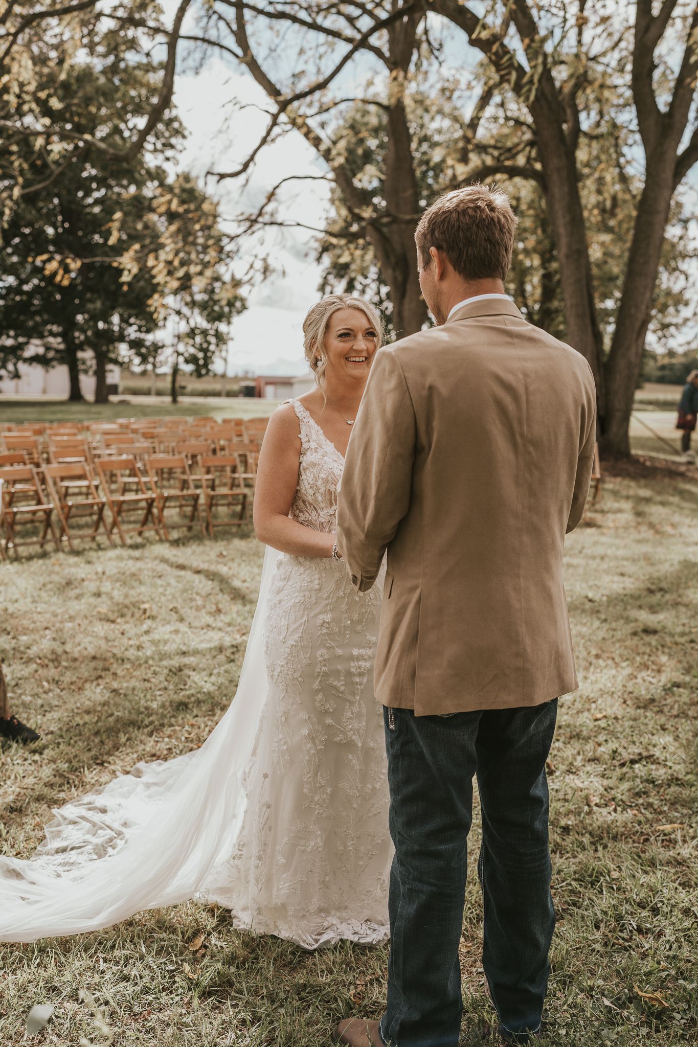 A couple shares a sweet first look moment in an outdoor garden setting during their wedding day.
