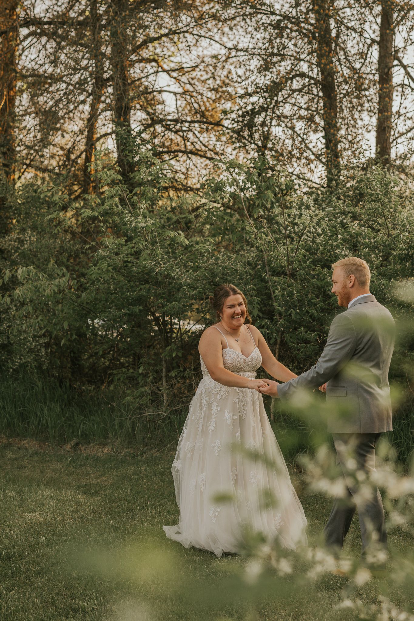A couple sharing a joyful dance moment in a garden setting.