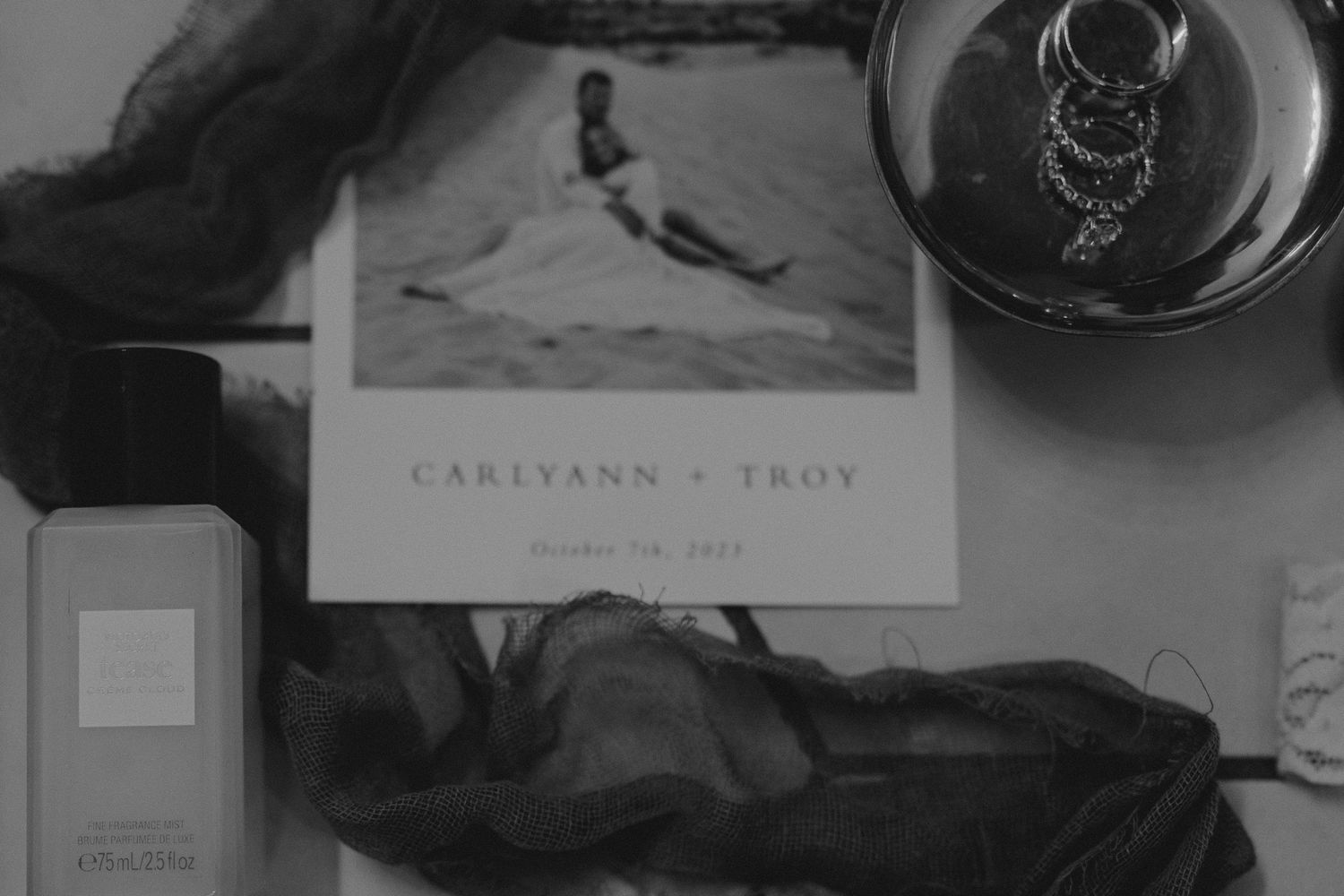 Elegant black and white wedding stationery and invitation details laid out on a dark surface.
