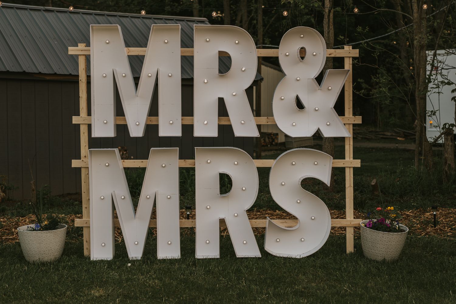 Large white 'MR & MRS' sign display against dark building backdrop.