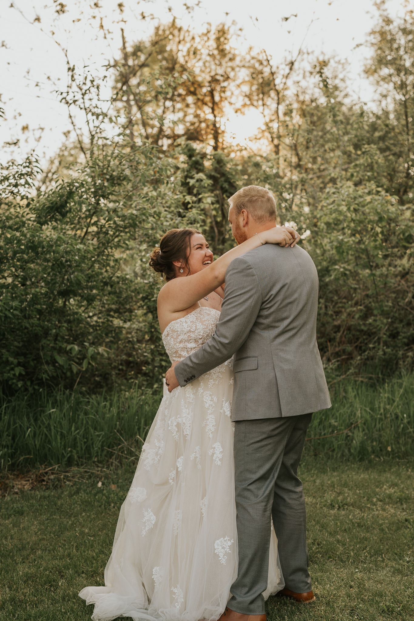 A romantic Michigan outdoor wedding moment captured in warm sunset lighting.