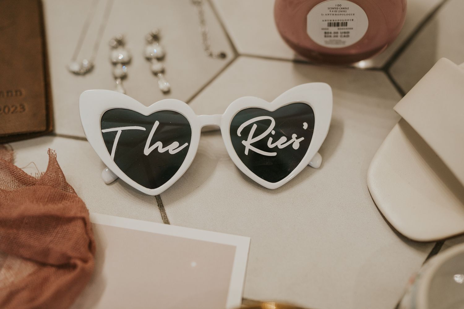 Modern wedding details including heart-shaped decorations and stationery elements on a light background.