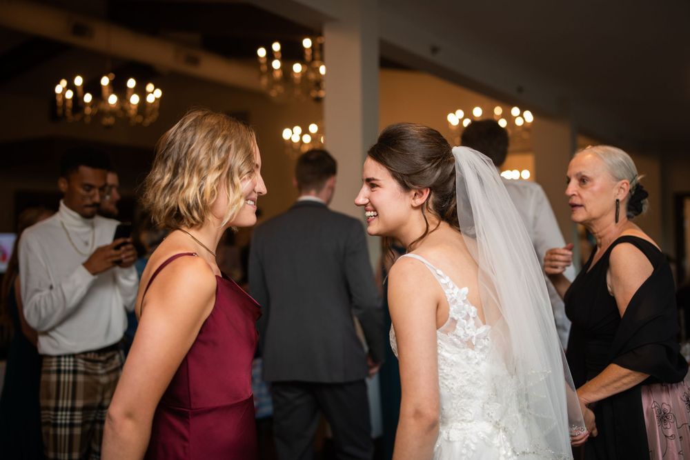 Bride and guest candid at wedding reception at Stratford Country Club