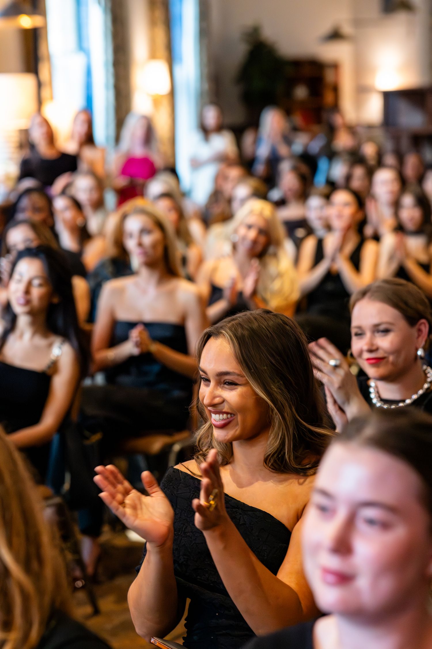 Crowd of people enjoying and applauding at an indoor event.