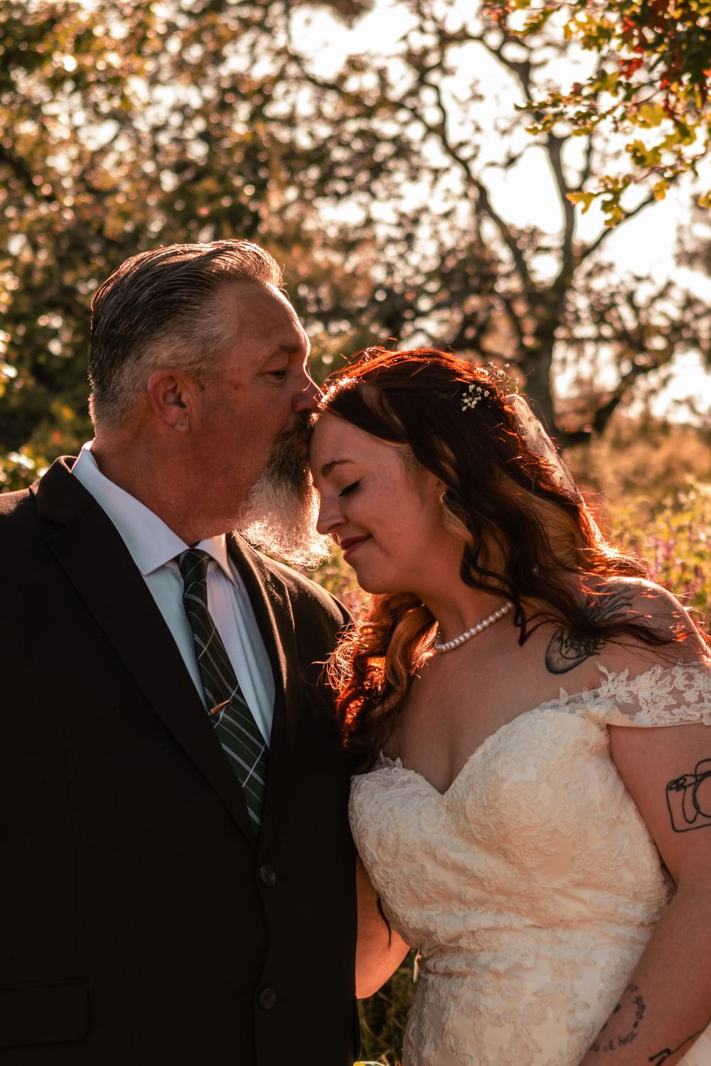 A bride is kissed by her father on the day of her commitment ceremony.
