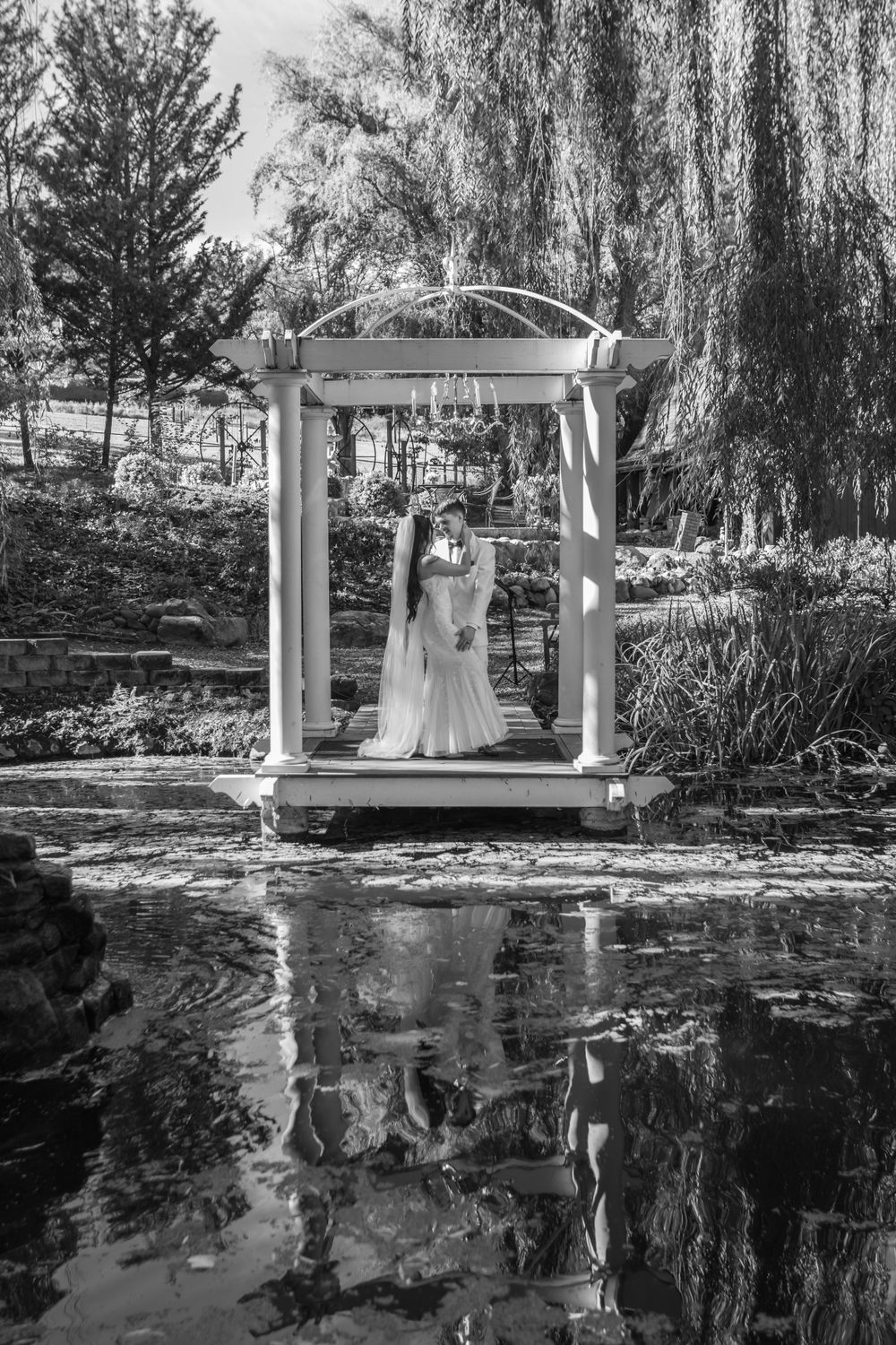 The wedding couple kisses at The Willows Venue in Central Point, Oregon, photographed in black and white.