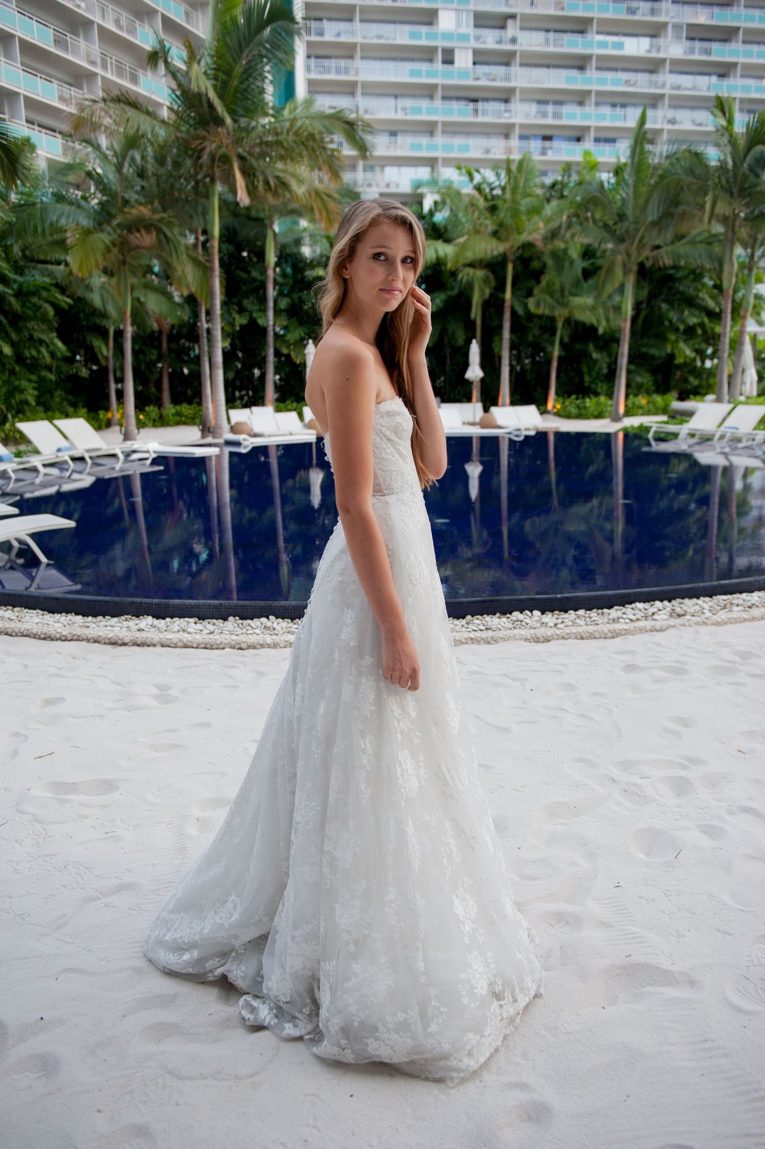 woman in a wedding gown standing at the roof top pool at the modern hotel, waikiki.