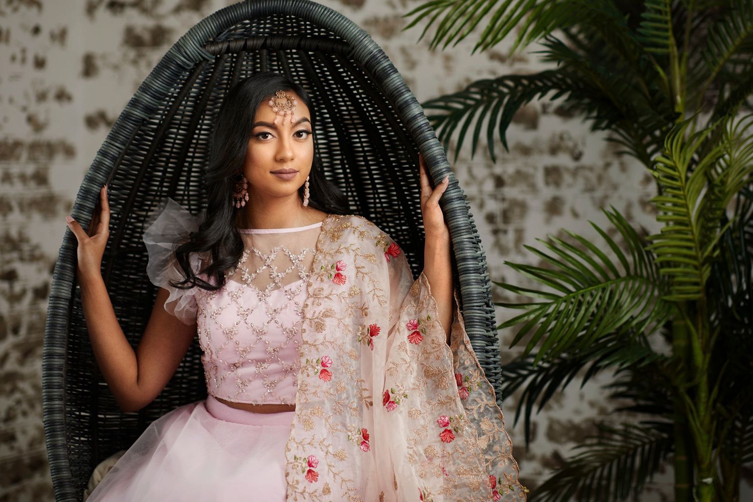Elegant portrait session featuring traditional South Asian attire against foliage backdrop.