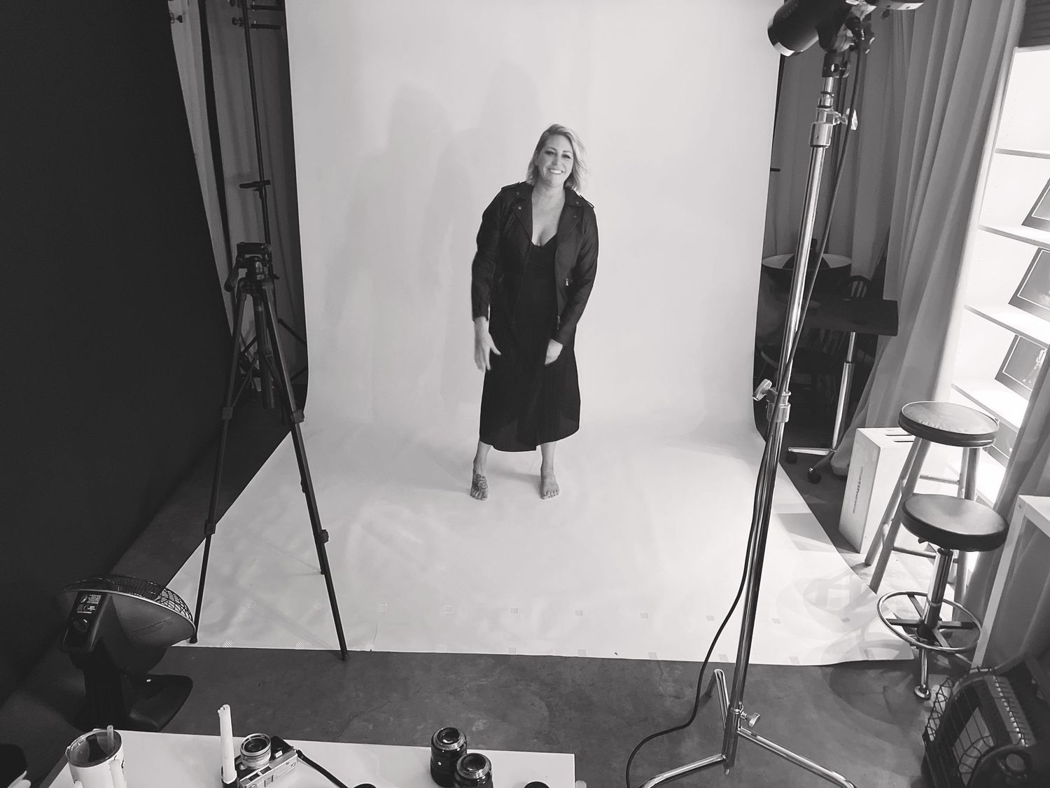 Behind-the-scenes photo shoot setup showing lighting equipment and backdrop in a professional studio.