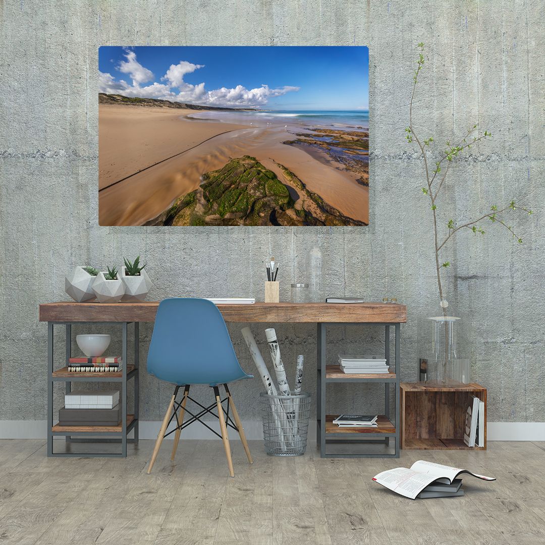 Minimalist room interior featuring coastal landscape artwork and modern furniture against concrete walls.