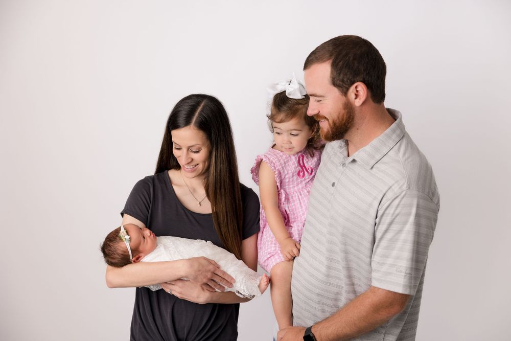 Happy family moment with newborn baby and toddler sibling.