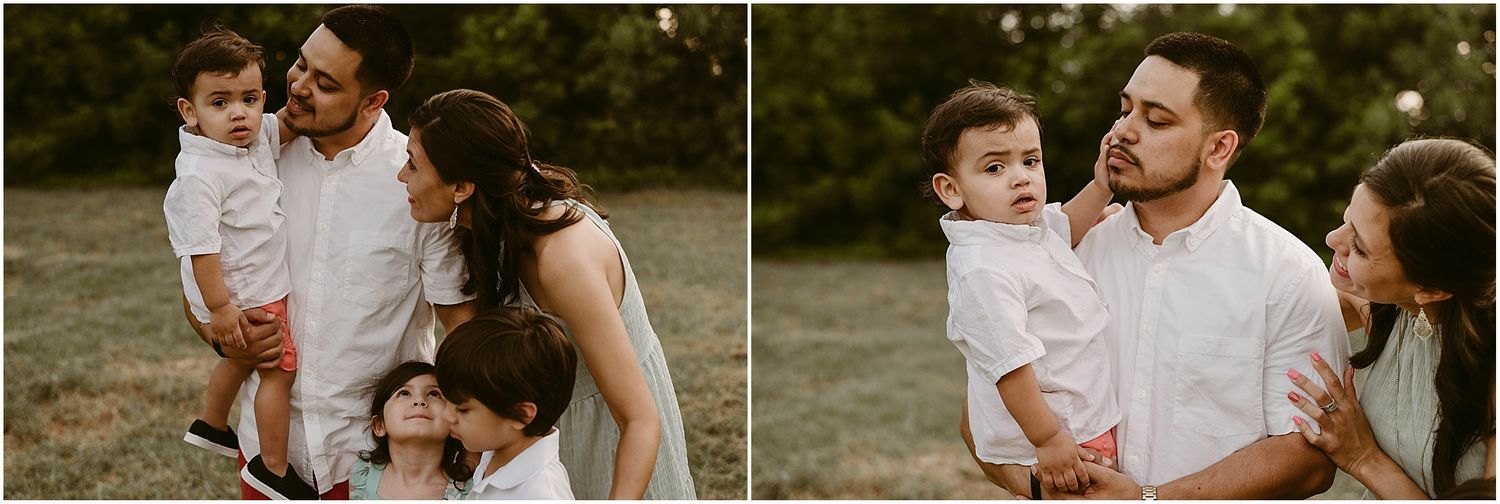 A family shares an intimate moment together during a sunset photoshoot in a field.