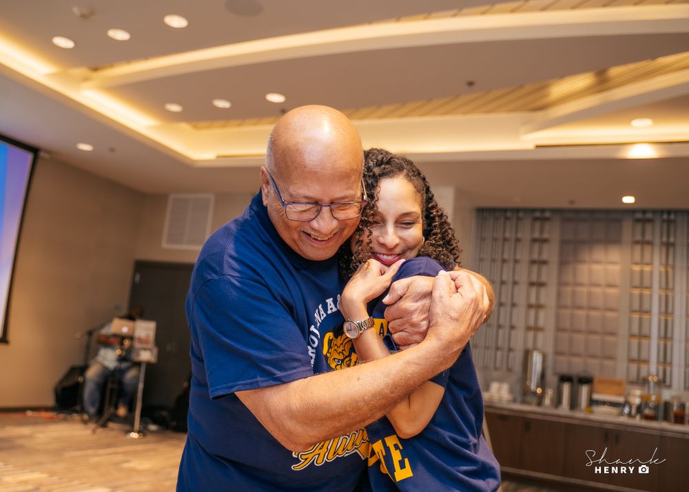 An emotional moment captured during a celebration event with blue and gold decor.