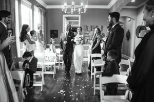 Intimate wedding ceremony in an elegant indoor venue with chandelier lighting.