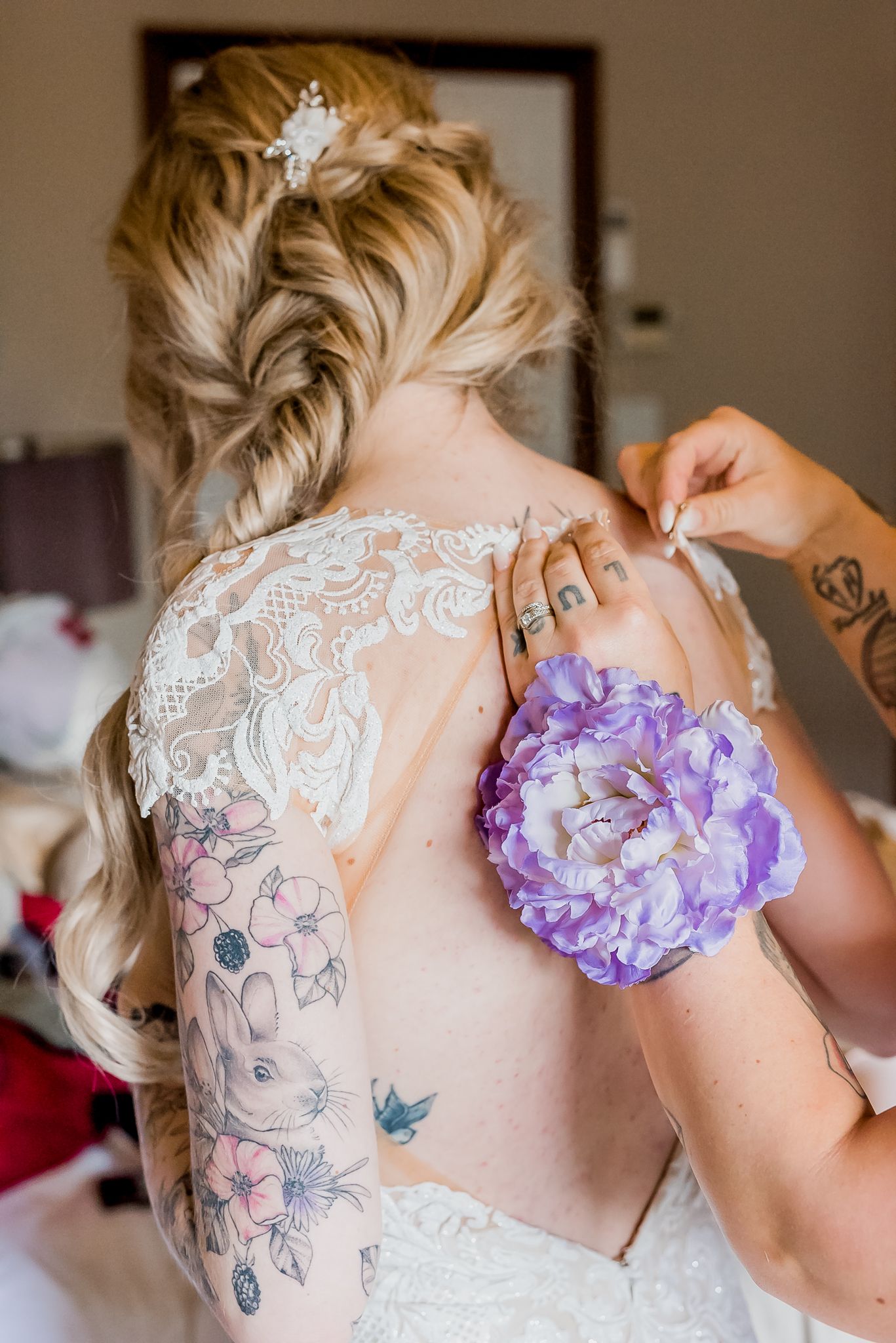Bridesmaid helping bride with dress on wedding day. Taken by Vancouver wedding photographer, Kari Mills Photography.