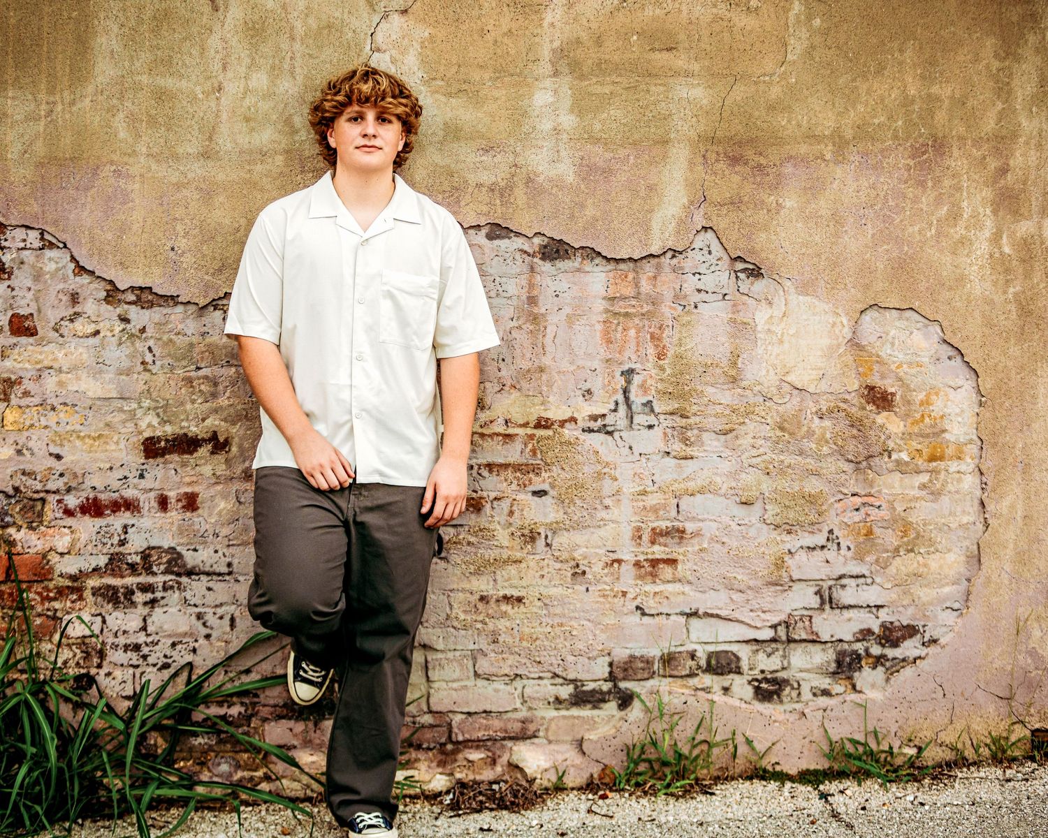 high school senior boy leaning against wall