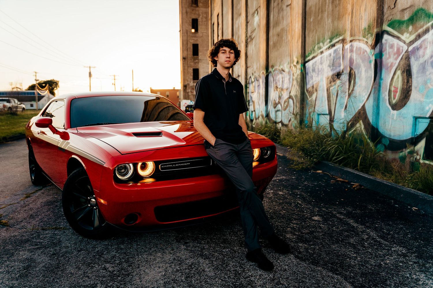 high school senior boy leaning against car