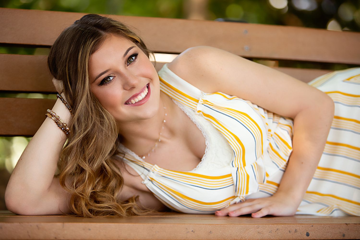 high school senior girl laying on bench