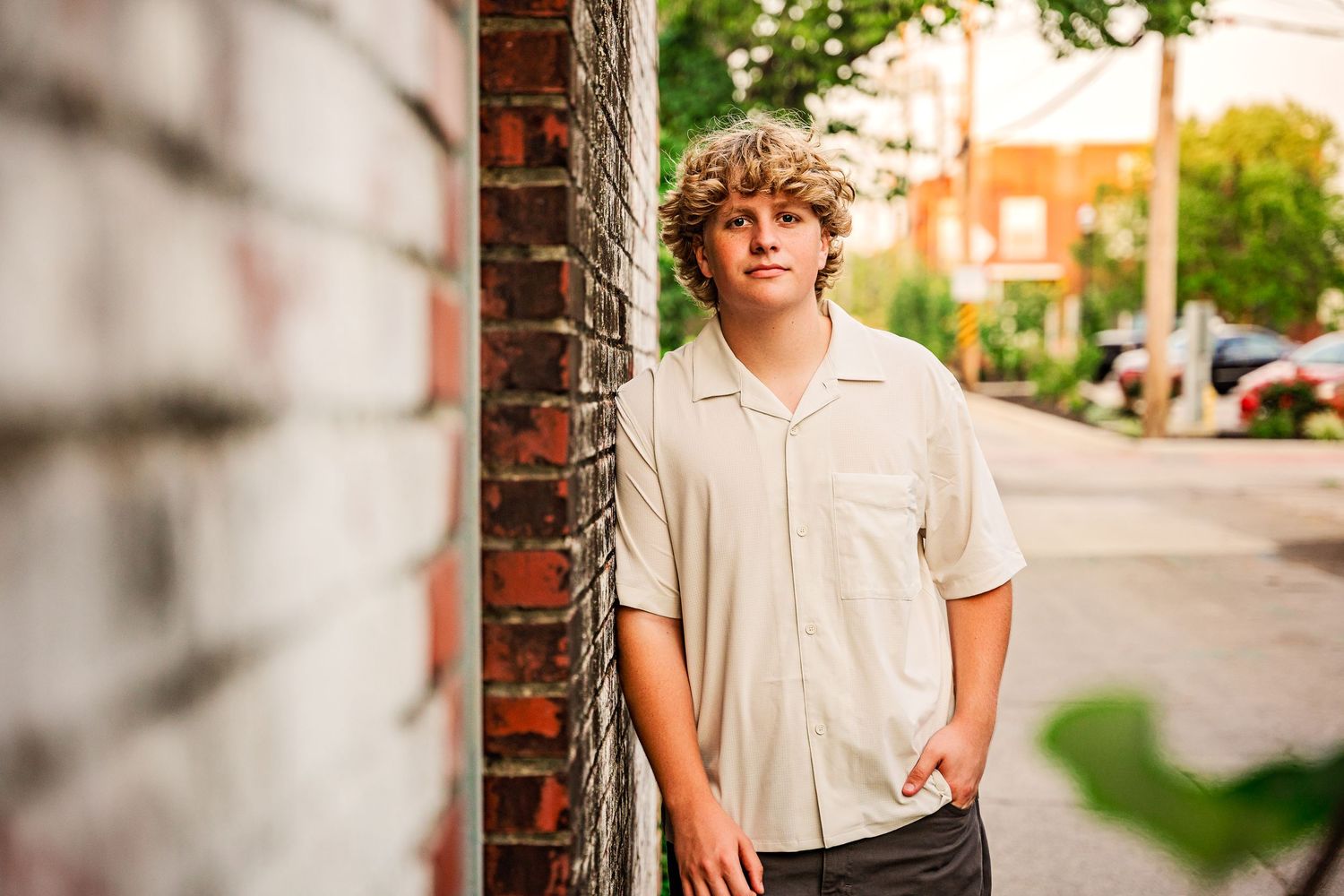 high school senior boy leaning against wall