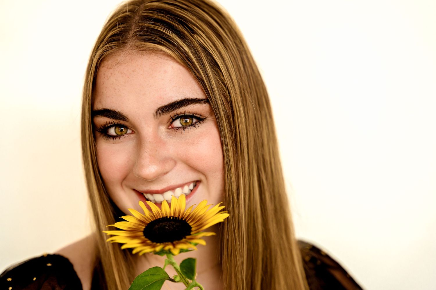 Studio portrait of high school senior girl and sunflower